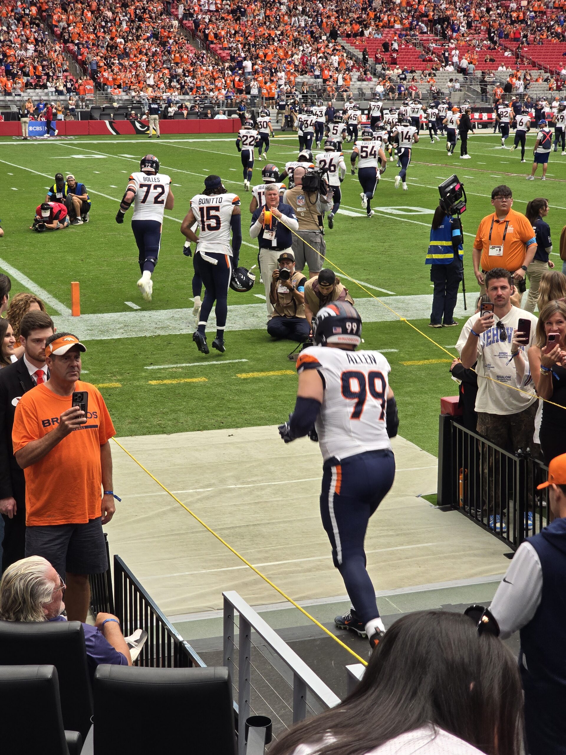Broncos players running out of the visitor tunnel onto the field