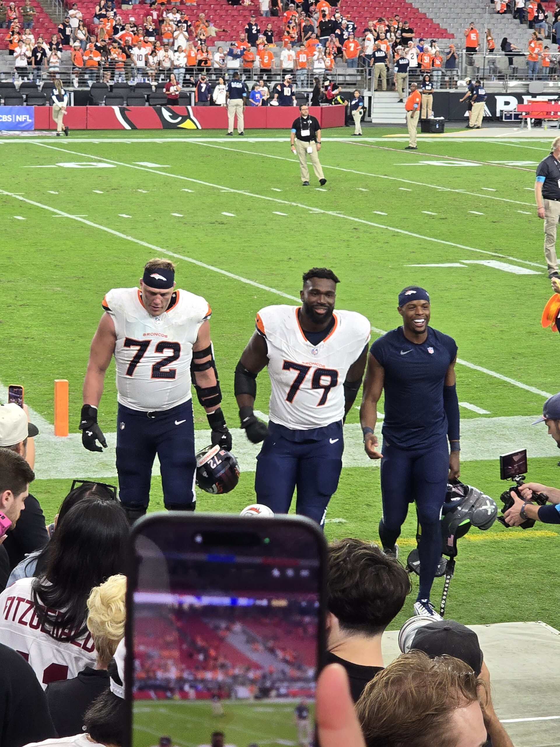 Smiling Broncos players walking toward the tunnel after the 30-16 win